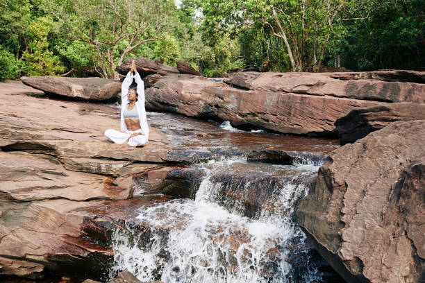 mujer meditando en la naturaleza - waterfall zen like women meditating fotografías e imágenes de stock