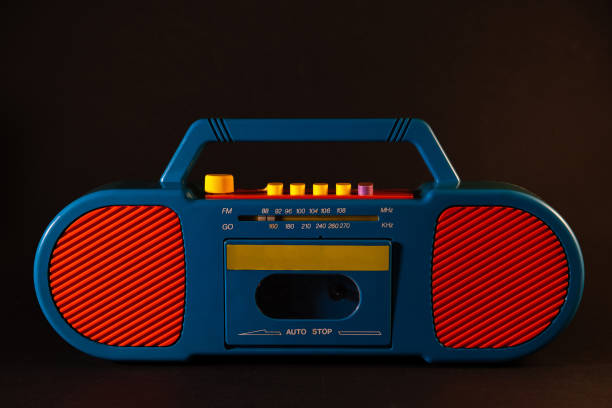 Old red-blue tape recorder on cassettes on a black background