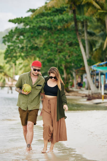 istock Young couple walking on the beach 1194252218
