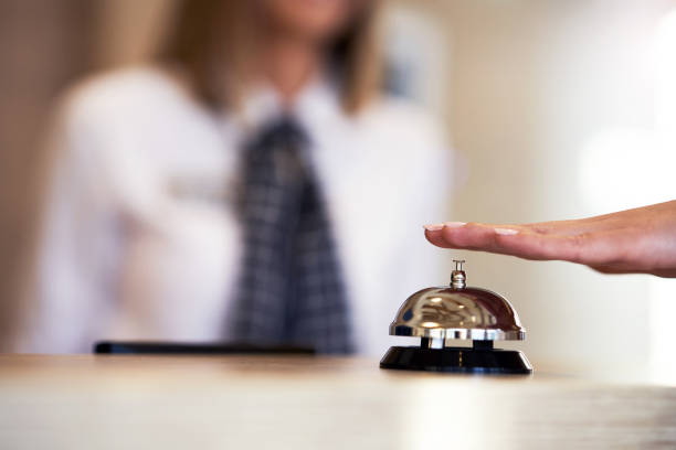 istock Businesswoman using bell at hotel front desk 1194252240