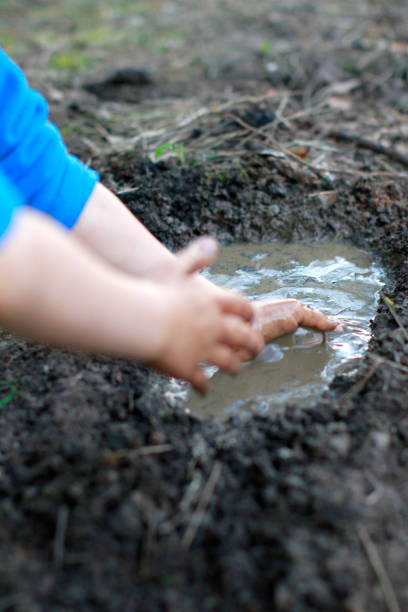 istock child arms playing with mud, creating a pond with happiness 1194252679