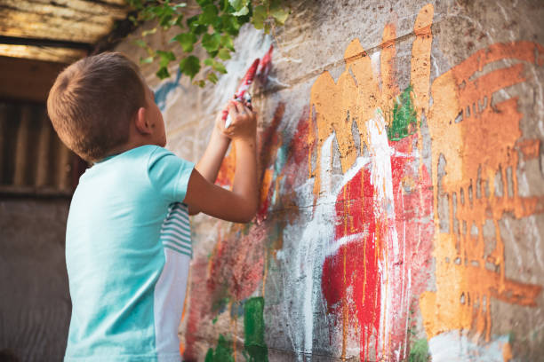 istock Cheerful little boy having fun painting wall 1194253327