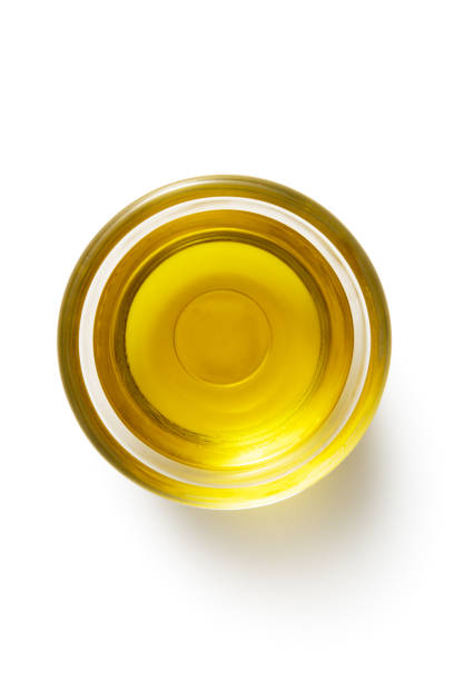 Glass bottle with olive oil and blue napkin on a wooden table. Shallow depth of field. Background blurred