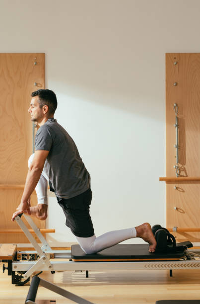 istock Sportsman Doing Reformer Pilates Exercise 1194258100
