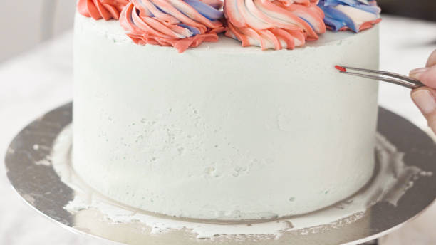 istock Placing color sprinkles on the sides of round three-layer vanilla cake. 1194259691