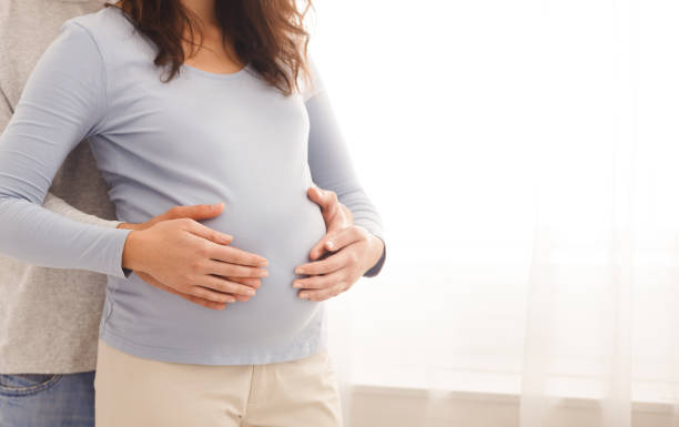 istock Loving husband tenderly touching his wife's belly 1194261690