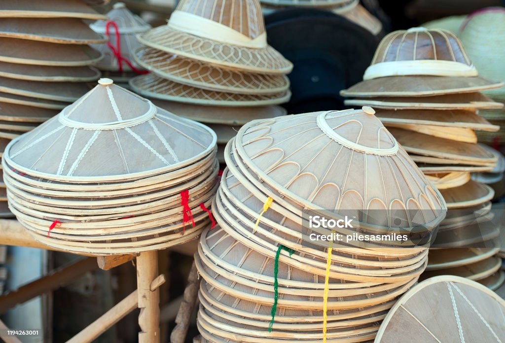 Handicrafts around Inle Lake - Conical Coolie Hats Conical Coolie Hats stacked on a market stall, Inle Lake Life, Shan State, Myanmar.  One of the local products at the picturesque fresh water Inle Lake with its tranquil waters, tributaries, inlets and floating agricultural gardens is the second largest  and highest altitude lake in Myanmar, with a rich wealthy hive of activity, cottage industry,  handicrafts and subsistence farming that makes it one of the most productive places for its ethnic group of Inntha, or Inn Tha self-sufficient farmers Activity Stock Photo