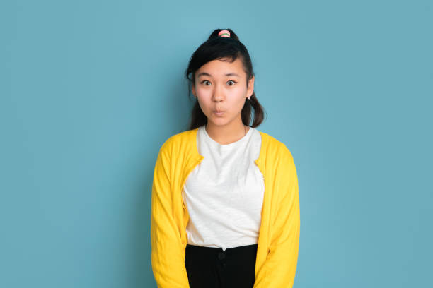 istock Asian teenager's portrait isolated on blue studio background 1194263592