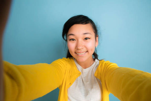 istock Asian teenager's portrait isolated on blue studio background 1194263619