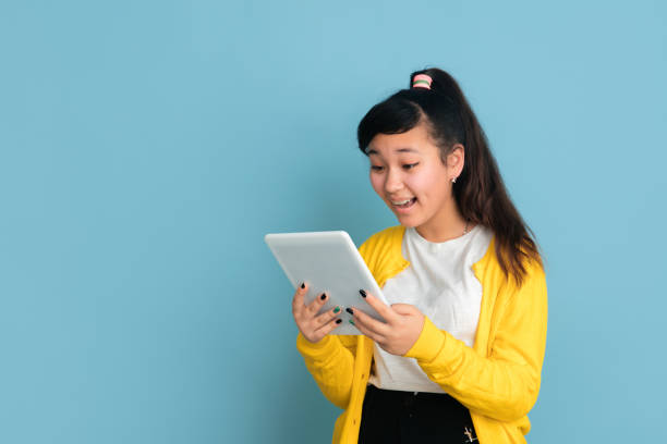 istock Asian teenager's portrait isolated on blue studio background 1194263626