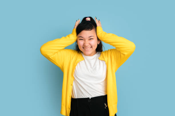 istock Asian teenager's portrait isolated on blue studio background 1194263640