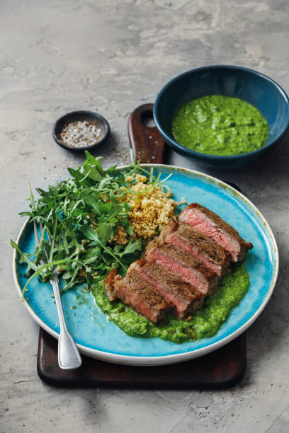 Argentine steak Asado. Argentine style steak with chimichurri sauce and quinoa salad. chimichurri stock pictures, royalty-free photos & images