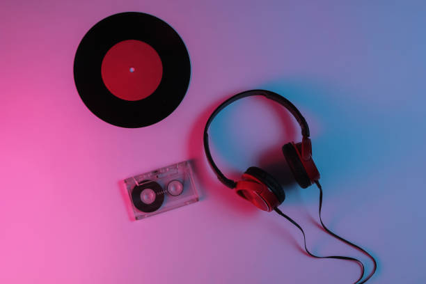 istock Wired headphone, vinyl record, audio cassette with neon blue-red gradient light. Retro wave, 80s pop culture. Top view 1194266755