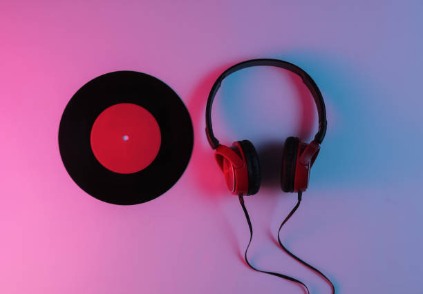 istock Wired headphone and vinyl record with neon blue-red gradient light. Retro wave, 80s pop culture. Top view 1194266844