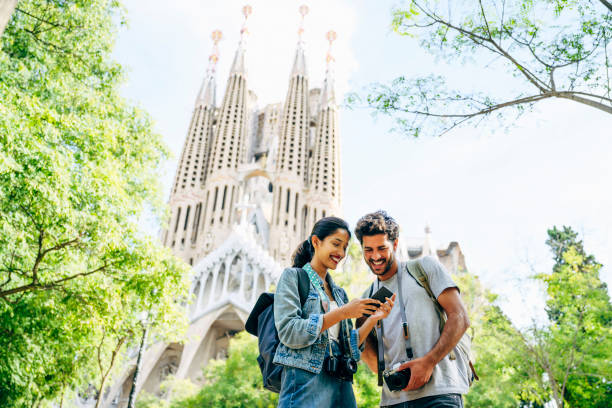 cheerful tourists checking smart phone near sagrada familia - tourists couple barcelona imagens e fotografias de stock