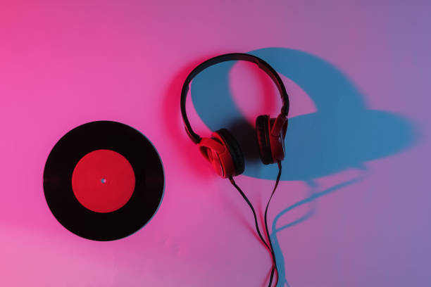 istock Wired headphone and vinyl record with neon blue-red gradient light. Retro wave, 80s pop culture. Top view 1194267034