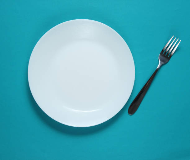 istock Empty plate with a fork on blue background. Studio shot. Restaurant food concept. Top view 1194267977