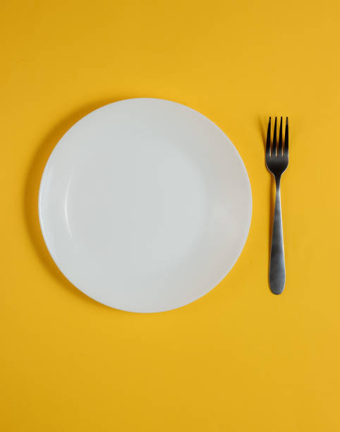 istock Empty plate with a fork on a yellow background. Studio shot. Restaurant food concept. 1194268072
