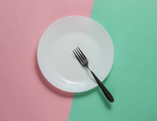 istock Empty plate with a fork on pink blue pastel background. Studio shot. Restaurant food concept. 1194268718