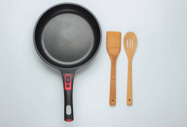istock Non-stick pan with cooking spatula on white background. Cooking minimalism concept. Top view 1194268753