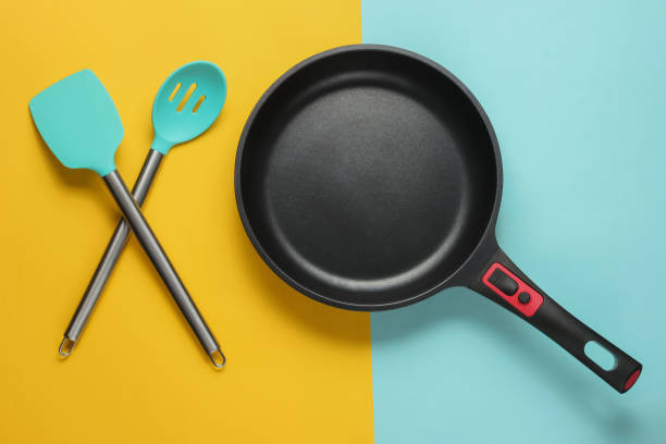 istock Non-stick pan with cooking spatula on blue yellow background. Cooking minimalism concept. Studio shot. Top view 1194268846