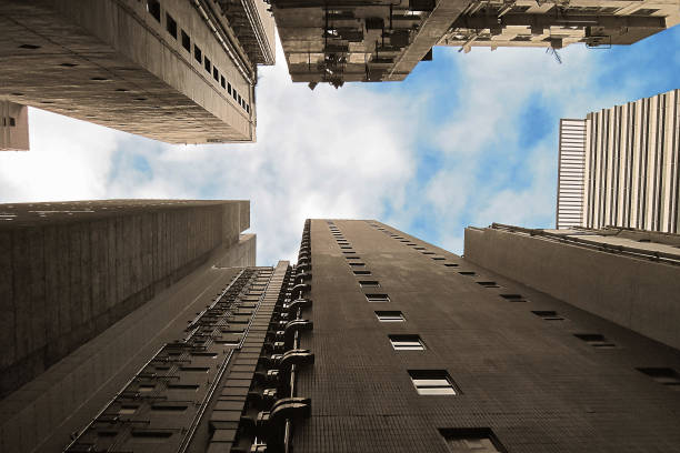 istock Sky between buildings. Low angle view from the ground on raising skyscrapers and cloudy blue sky. Urban landscape of modern megalopolis skyline 1194269911