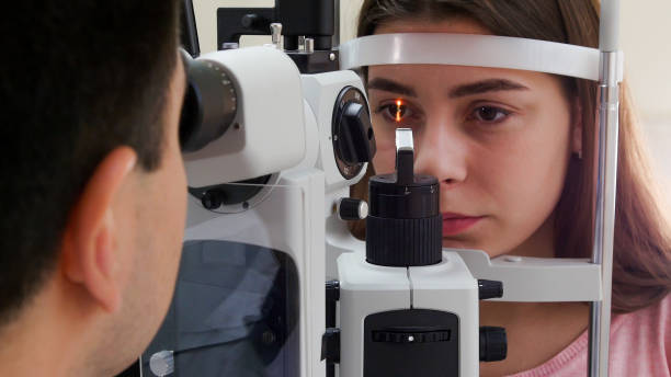 istock Ophthalmology treatment - a young woman with pink lips checking her visual acuity - pupil reaction to light 1194270938