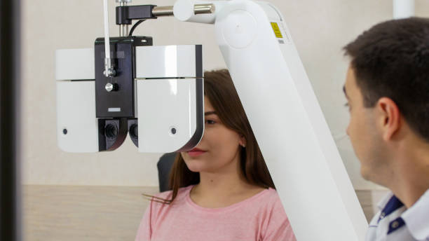 istock Ophthalmology treatment - a young woman checking her visual acuity with a special big optometry machine 1194271333