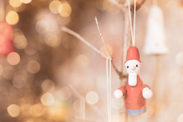 A Multiple Exposure of old wooden christmas tree ornaments and golden white bokeh background