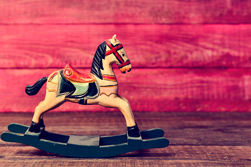 an old wooden rocking horse on a rustic wooden surface