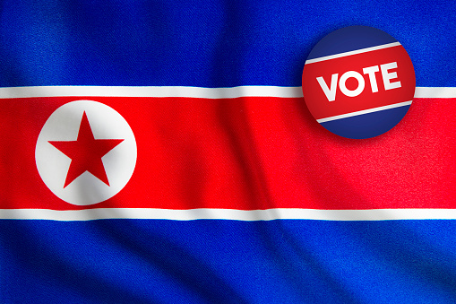 Vote Badge over North Korean Flag. Horizontal composition with copy space.
