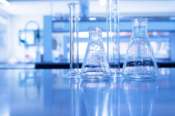 istock flask and cylinder with water drop in blue science education background 1194274381