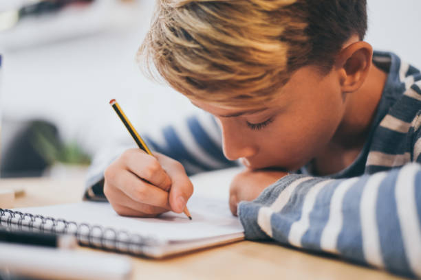 istock Close-Up Of Boy Drawing In Note Pad At Table 1194276405