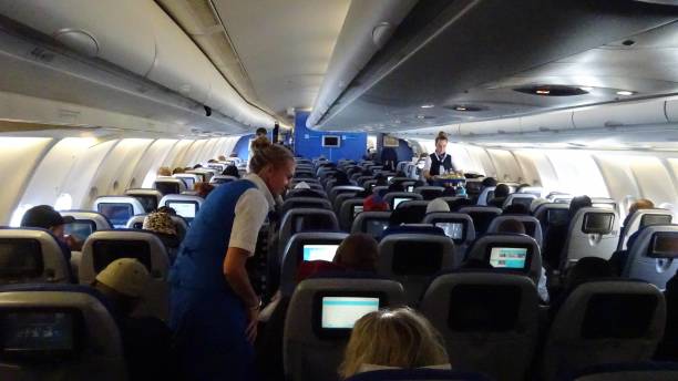 KLM Airlines, Stewardess, Passengers View After Taking Off From Amsterdam Schiphol International Airport. Holland. Europe View Of People Sitting Down, Watching Movie, Playing Music, Stewardess Standing, Talking To Passengers, Serving Food And Drinks To Passengers Inside KLM Airlines Passenger Airplane After Taking Off From Amsterdam Schiphol International Airport In The Netherlands Europe jump jet stock pictures, royalty-free photos & images