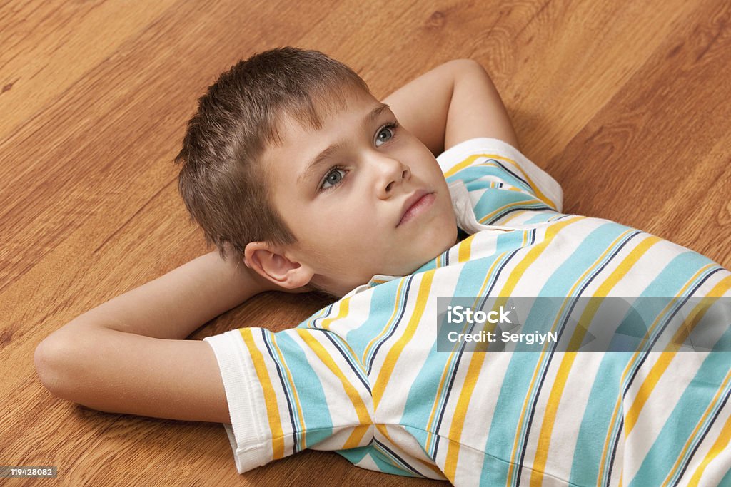 Thoughtful boy  on the wooden floor  Boys Stock Photo