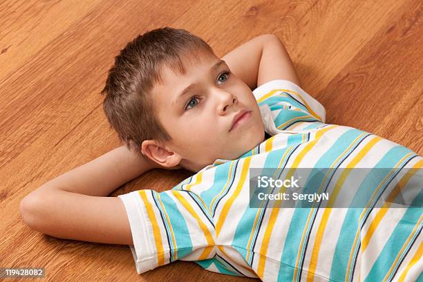 Thoughtful Boy On The Wooden Floor Stock Photo - Download Image Now - Boys, Elementary Age, White People