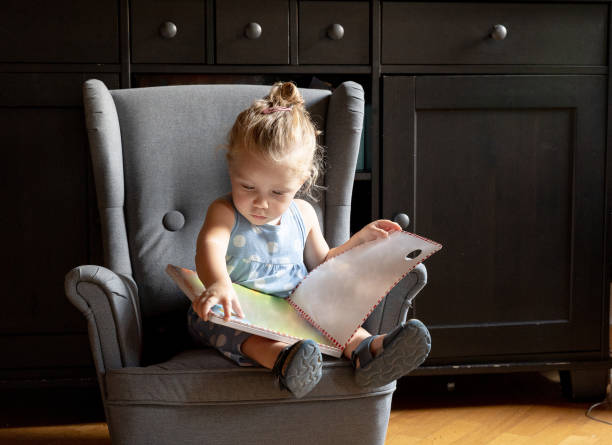 baby Girl reading a picture Book at Home stock photo