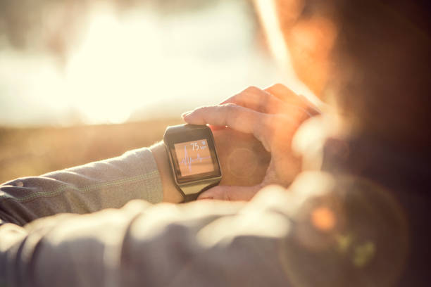 comprobación de su frecuencia cardíaca en un reloj inteligente en la mañana después de correr - city street audio fotografías e imágenes de stock