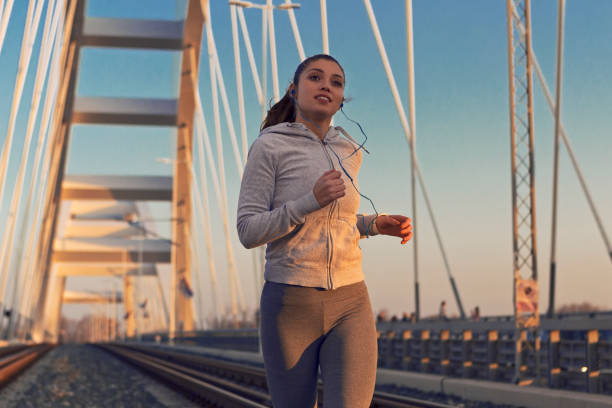istock Sportswoman running on bridge on a sunny day 1194284676