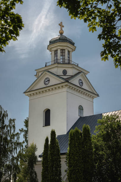 istock White church tower surrounded by green foliage 1194285545