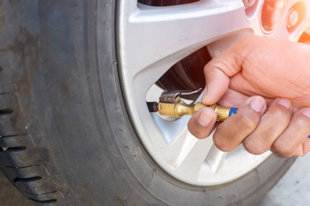 istock man inflating tire on his car. 1194289386