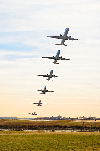Photo illustrates an aircraft taking off from runway with sunset background. The photo is composed from 6 different photos to show the aircraft's path. Photos were taken at Washington DCA airport.