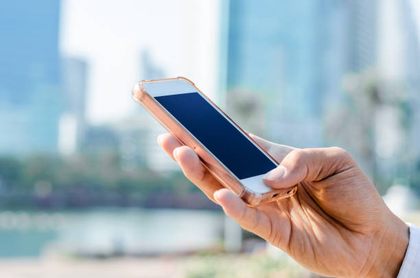 istock 5G technology world wide web connecting.close up business man using hand typing smartphones and touch screen working search with app devices outdoor in city with sunrise and building background. 1194292245