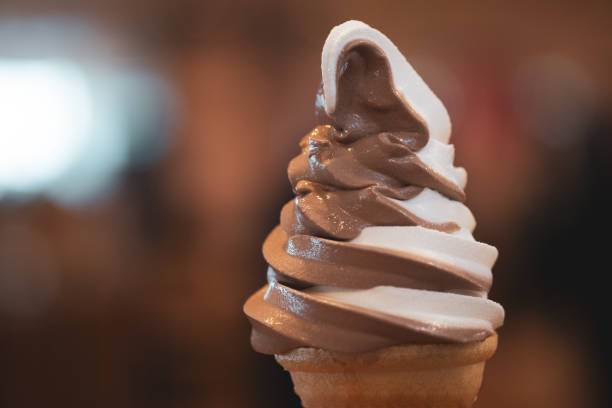 mão que prende um cone macio do gelado do saque de dois tons - soft serve ice cream - fotografias e filmes do acervo