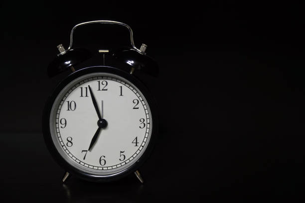 istock Classic mechanical alarm clock on dark background 1194293566