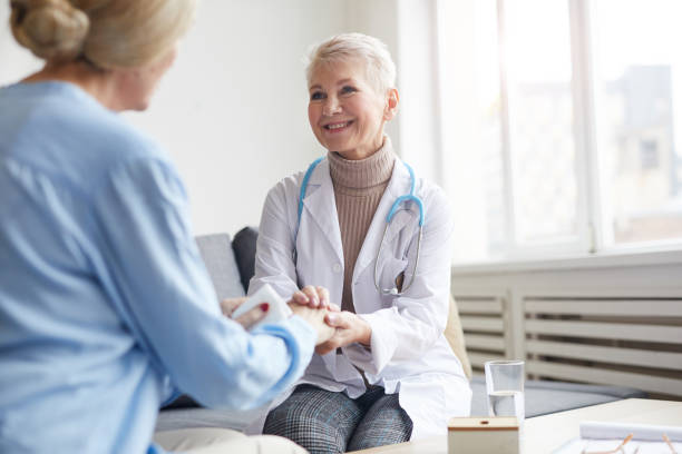 istock Smiling Female Dostor Holding Hands with Patient 1194294386