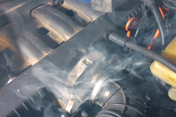 Smoke under the hood of car. Car engine smokes. stock photo