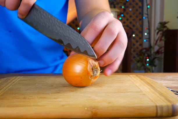 istock Slicing the onion with a knife on cutting board. 1194296261