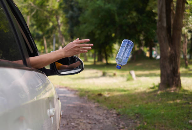 istock Close up, Throwing away plastic bottle from car window. 1194298661