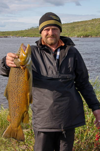 istock Fisherman caught a trophy brown trout. 1194300279